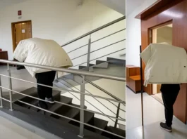 delivery man climbing stairs with heavy parcel